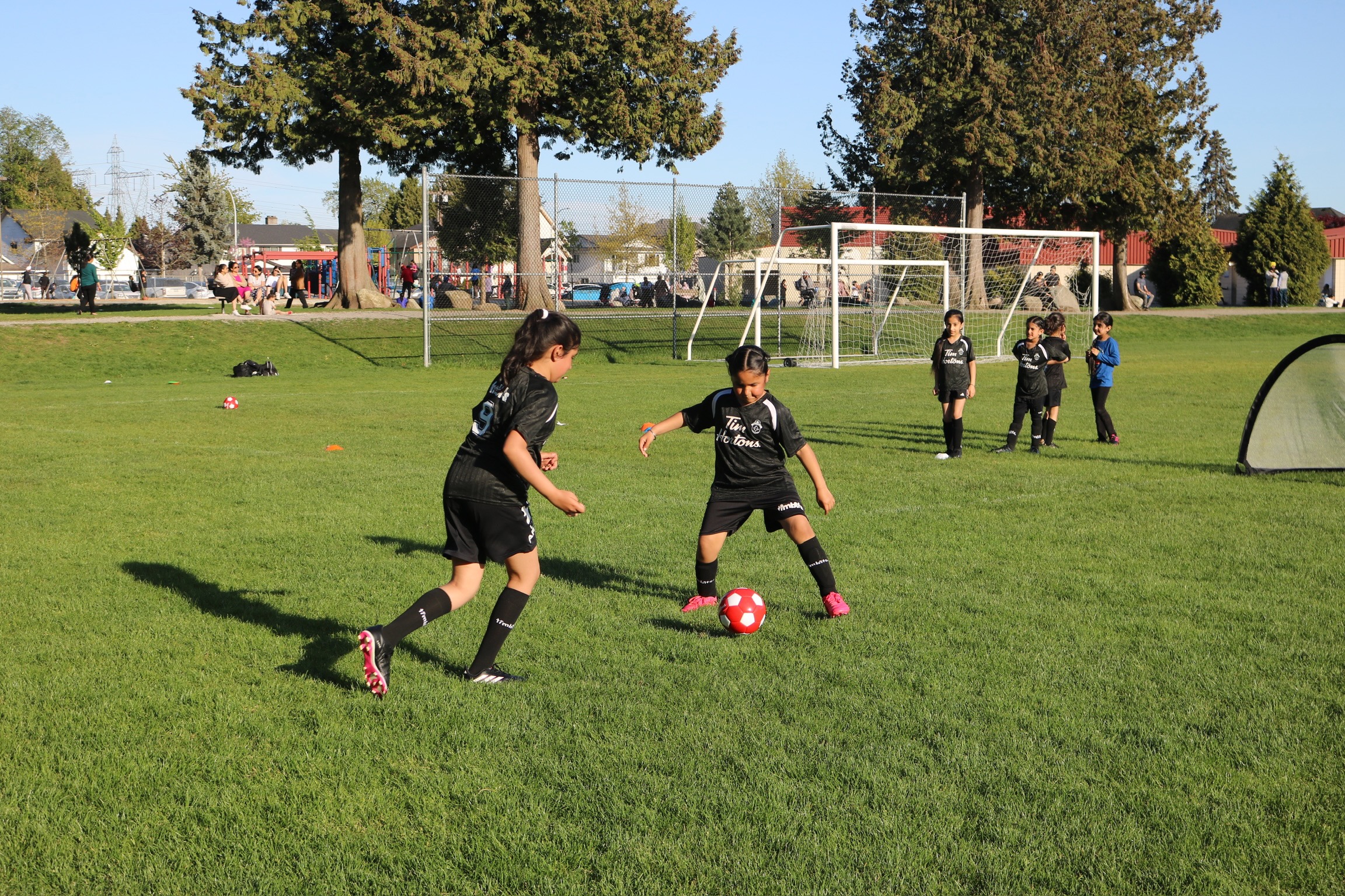 Two girls dribbling a soccer ball